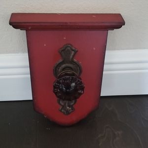 Red wall hanging includes a knob and hook
